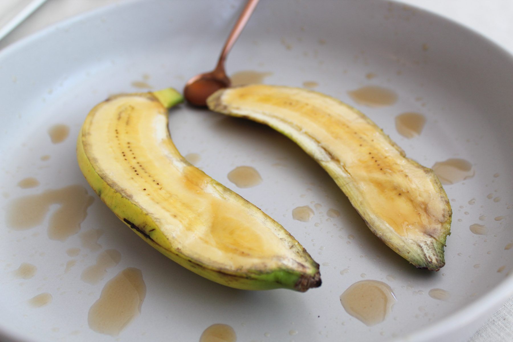 Plátano asado abierto con gotas de vinagre en un plato